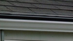 Leafree gutter guards installed on top of white 5-inch gutters