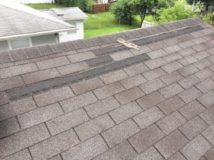 roof shingles creased and broken from wind and hail damage