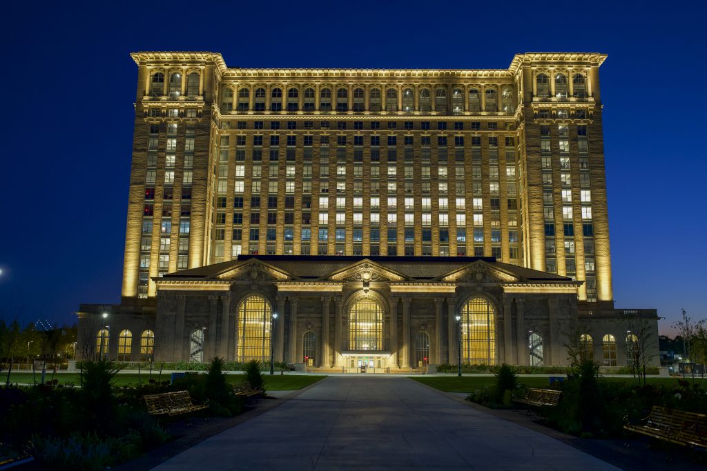 revitalized detroit, michigan, train station lit up at dusk set to a dark blue sky